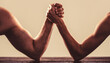 © Yevhen - Two man's hands clasped arm wrestling, strong and weak, unequal match