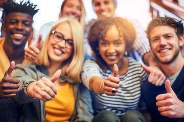 Sticker - Its a thumbs up to higher education. Portrait of a group of diverse university students showing a thumbs up while sitting on the staircase on campus.