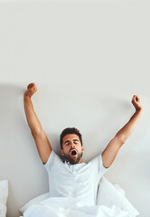 Poster - What a great nights sleep. Cropped shot of a tired young man stretching and yawning after waking up from a good nights sleep.