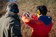 Trainer helping young person to aim with handgun at combat training. High quality photo