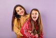 © nastia1983 - Happy laughing playful young mother and cute enjoying daughter posing in fashion trendy hoodie together on purple studio background with empty copy space. Happy loving