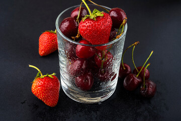 Canvas Print - Strawberries and cherries in a glass covered with water drops. Fruit cocktail. Fresh berries. Vitamin cocktail