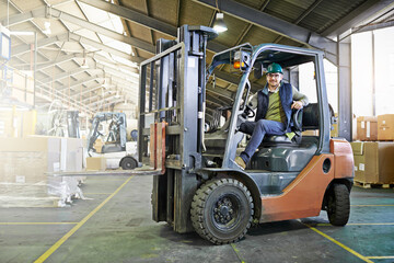 Poster - Time to get things moving around here. Portrait of driver in a forklift on the factory floor.