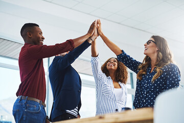 Poster - Creativity leads to inspiration and determination, which leads to success. Cropped shot of a group of creative employees high fiving while celebrating in a modern office.
