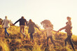 © Mariusz S/peopleimages.com - And sothe adventures begin. A multi-generational family walking up a grassy hill together at sunse.