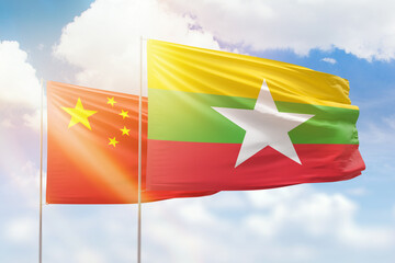 Wall Mural - Sunny blue sky and flags of myanmar and china