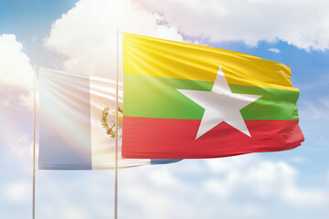 Sunny blue sky and flags of myanmar and guatemala