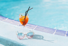 Glass Of Cocktail With Ice And Sunglasses On Hotel Pool, Summer Vacation