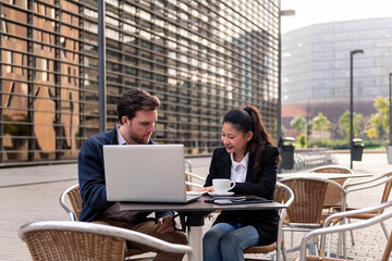 woman and man business partners have a work meeting on the terrace of a coffee shop, concept of entrepreneurship and business, copy space for text