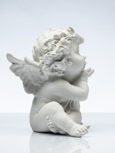 Plaster White Statuette In The Form Of An Angel On A White Background