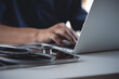 © tippapatt - Close up of doctor, sugeon working on laptop computer with digital tablet on table in doctor's office, medical research, healthcare and medicine concept