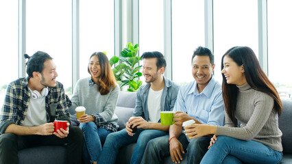 Group of happy creative team talking while taking coffee break at office