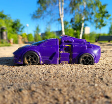 Toy Small Purple Car In The Sandbox On The Playground