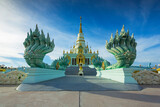 Fototapeta  - Beautiful relics and naga statue behind the blue sky in Wat Saensuk Suthi Wararam at Chonburi, Thailand