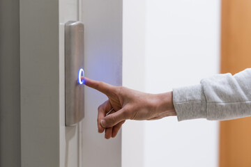 Person's hand calling elevator by pressing button