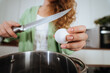 © teksomolika - Young woman is preparing food in the kitchen. Beating eggs.