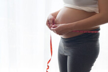 Young Pregnant Woman Measuring Belly Centimeter, Healthcare And Pregnancy Care