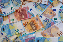 Euro Banknotes In Various Denominations. Pile Of Banknotes On The Table In Denominations Of Twenty Euros, Fifty Euros, Ten Euros, Five Euros. Background Of Mixed Euro Banknotes