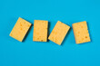 Yellow porous sponges for cleaning on a blue background with copy space