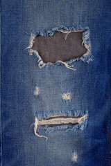 Wall Mural - Blue jeans denim background texture. Torn jeans fabric material surface