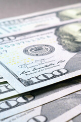 Wall Mural - american paper money. several one hundred dollar banknotes lie on gray textured surface. focus on th