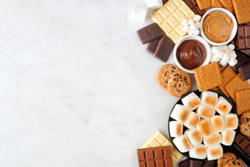 Poster - Smores buffet side border. Roasted marshmallows, crackers, chocolate and assorted ingredients. Top view over a white marble background.