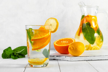 Wall Mural - Citrus drink with lemon, orange and mint. Healthy and healthy drink in a transparent glass with copy space