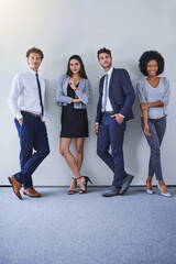 Poster - Theyre a team built to last. Portrait of a diverse group of businesspeople standing against a grey background.