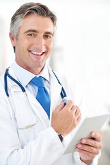 Poster - The results are in. Portrait of a doctor holding a digital tablet while standing in a hospital corridor.