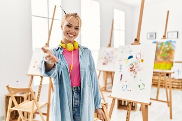 Poster - Young caucasian girl at art studio smiling cheerful offering palm hand giving assistance and acceptance.