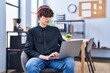 © Krakenimages.com - Young hispanic man business worker listening to music using laptop at office
