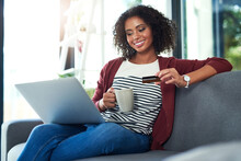 Me Time Is Treat Time. Shot Of A Young Woman Using A Laptop And Credit Card On The Sofa At Home.