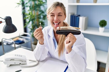 Canvas Print - Beautiful dentist woman comparing teeth whitening sticking tongue out happy with funny expression.