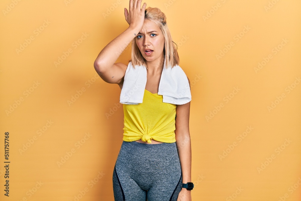 Beautiful blonde sports woman wearing workout outfit surprised with