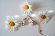 white daisy flowers, daisy shaped earrings on a white background