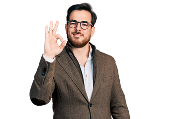 Wall Mural - Young hispanic man wearing business jacket and glasses smiling positive doing ok sign with hand and fingers. successful expression.