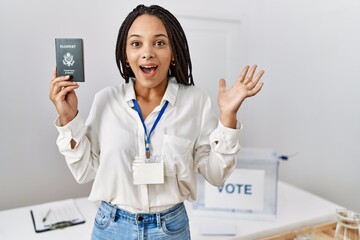 Wall Mural - Young african american woman at political campaign election holding usa passport celebrating victory with happy smile and winner expression with raised hands