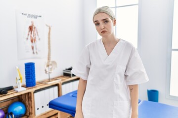 Sticker - Young caucasian woman working at pain recovery clinic looking sleepy and tired, exhausted for fatigue and hangover, lazy eyes in the morning.