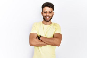 Canvas Print - Arab young man standing over isolated background happy face smiling with crossed arms looking at the camera. positive person.