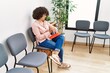 © Krakenimages.com - Young middle east woman looking watch sitting on chair at waiting room