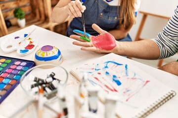 Wall Mural - Couple painting hands at art studio.