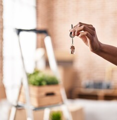 African american woman holding key standing at new home