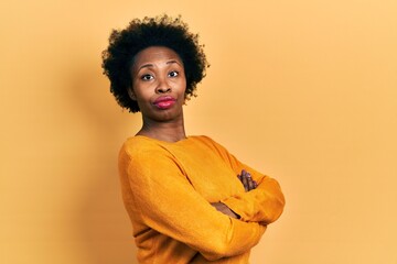 Poster - Young african american woman wearing casual clothes looking to the side with arms crossed convinced and confident