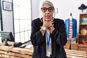 Wall Mural - Middle age grey-haired woman working as manager at retail boutique shouting and suffocate because painful strangle. health problem. asphyxiate and suicide concept.