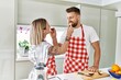 © Krakenimages.com - Young couple smiling confident giving fruit to each other at kitchen