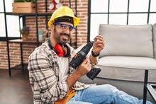 Young Hispanic Man Worker Smiling Confident Holding Drill At Home