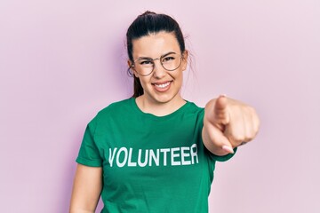 Poster - Young hispanic woman wearing volunteer t shirt pointing to you and the camera with fingers, smiling positive and cheerful