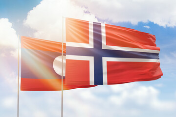 Sunny blue sky and flags of norway and laos