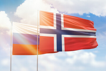 Sunny blue sky and flags of norway and russia