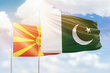 Sunny blue sky and flags of pakistan and north macedonia